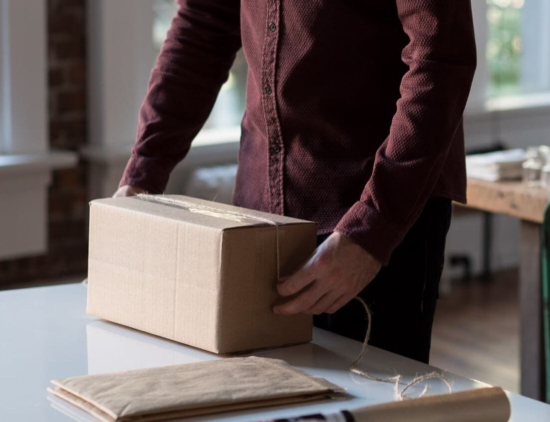 Man packing a parcel in his office
